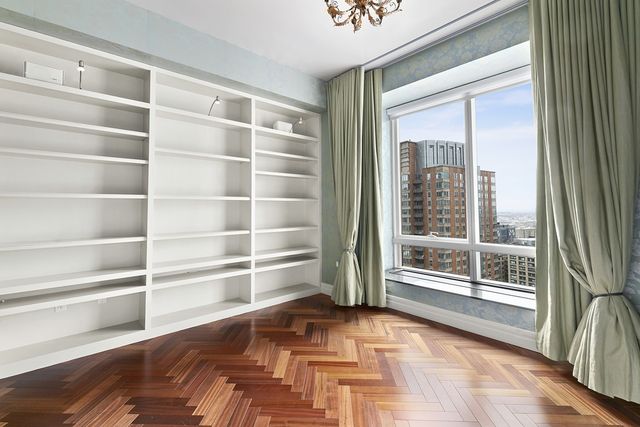 a view of empty room with wooden floor and windows