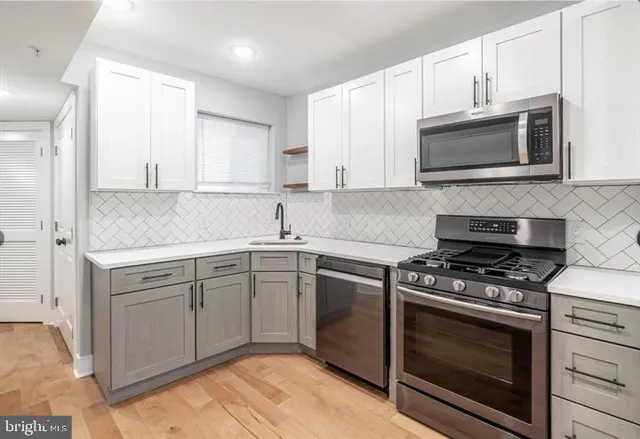 a kitchen with cabinets stainless steel appliances and a sink