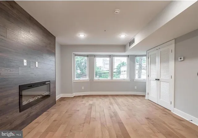 an empty room with wooden floor and windows