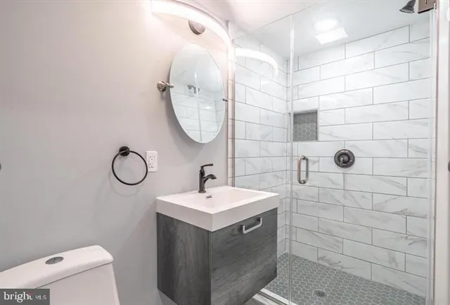 a bathroom with a sink a toilet and shower