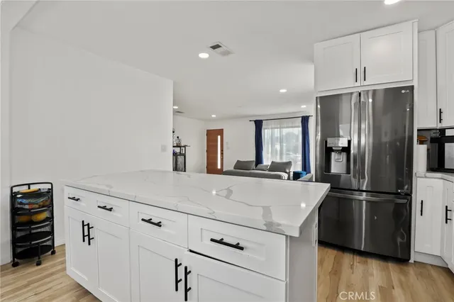 a kitchen with refrigerator cabinets and wooden floor