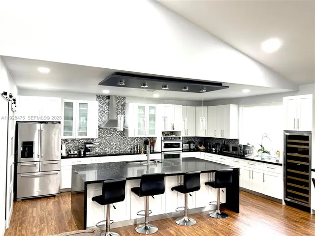a kitchen with a center island and stainless steel appliances