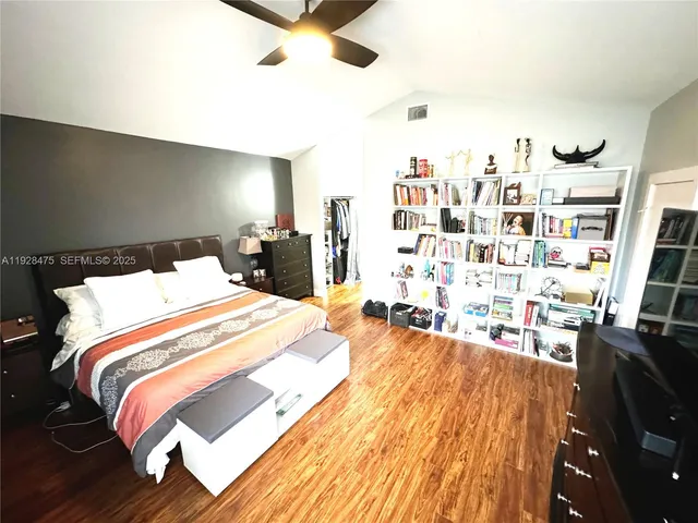 a bed sitting in a bedroom and a book shelf