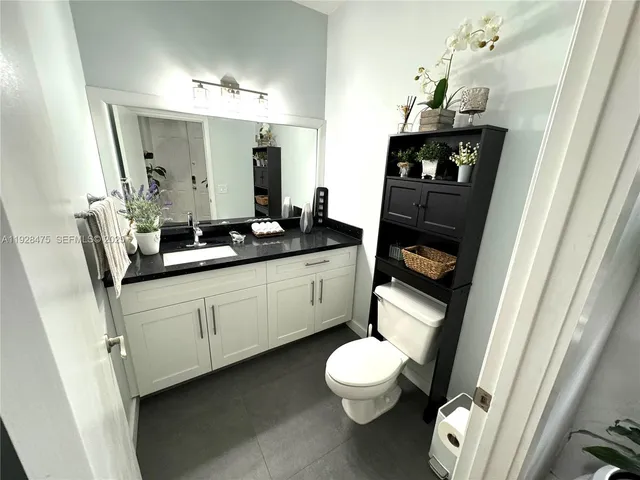 a bathroom with a toilet sink and mirror