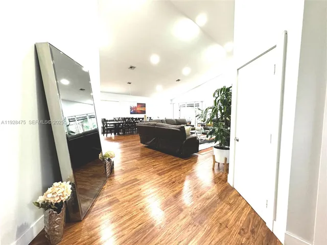 a view of a living room with furniture and wooden floor