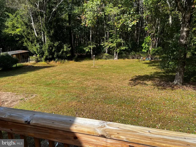 a view of swimming pool with lawn chairs and trees