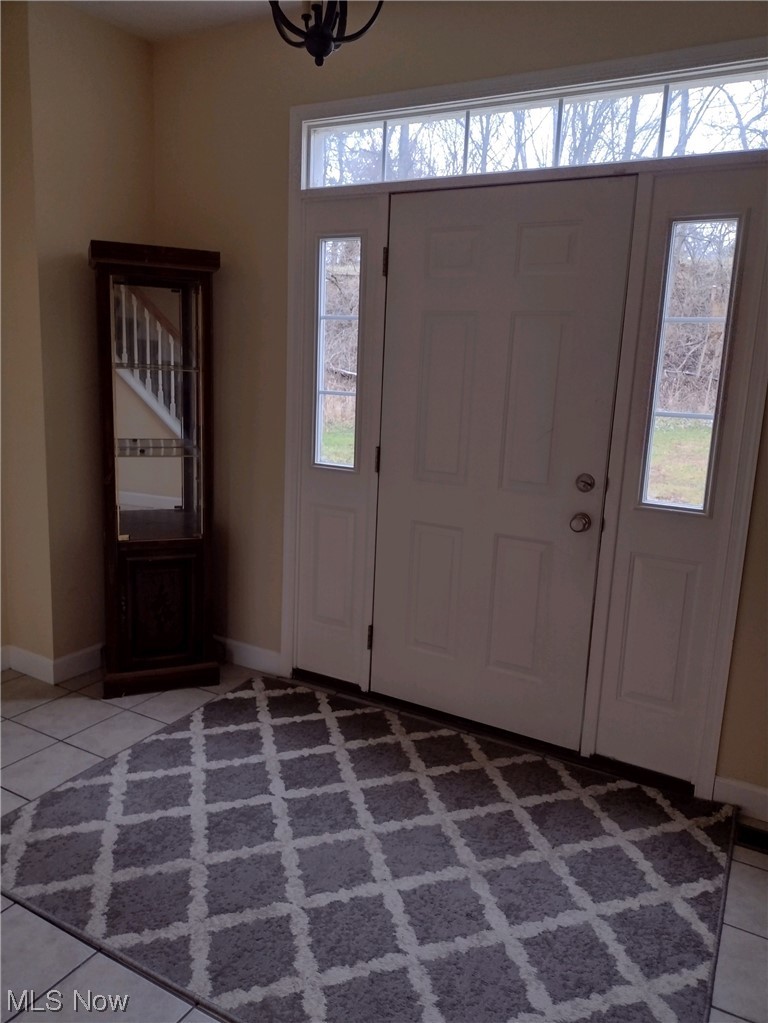3270 Ridge Road Zanesville, OH 43701 - Photo 3 of 17 Foyer featuring light tile floors and an inviting chandelier