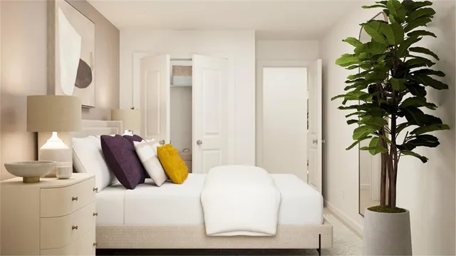 a bedroom with a bed and a potted plant