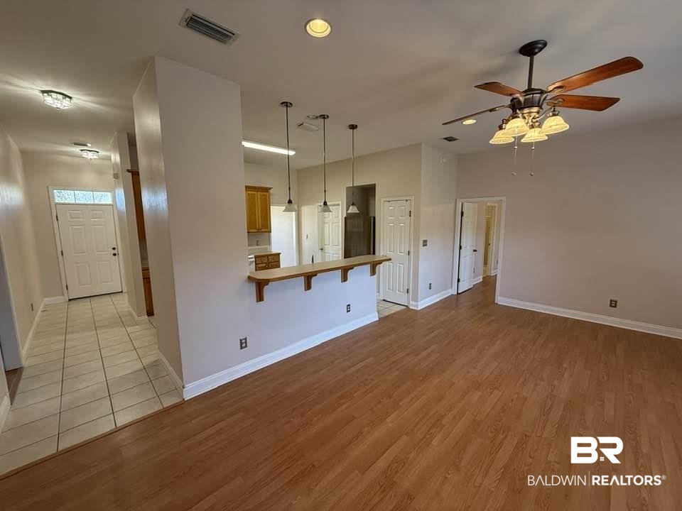 10428 South Side Loop Fairhope, AL 36532 - Photo 8 of 28 Unfurnished living room featuring light wood-style flooring, a ceiling fan, visible vents, and baseboards