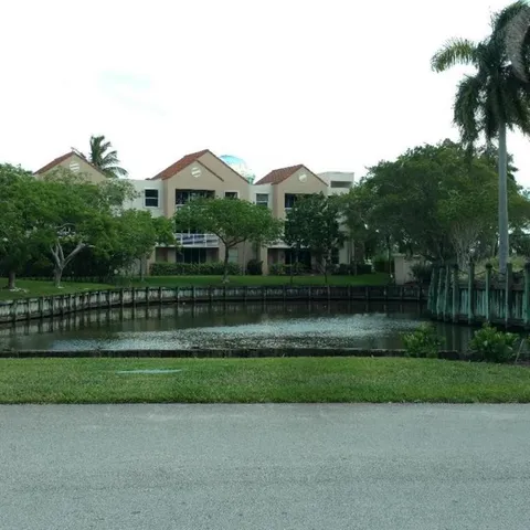 a front view of a house with a yard and green space