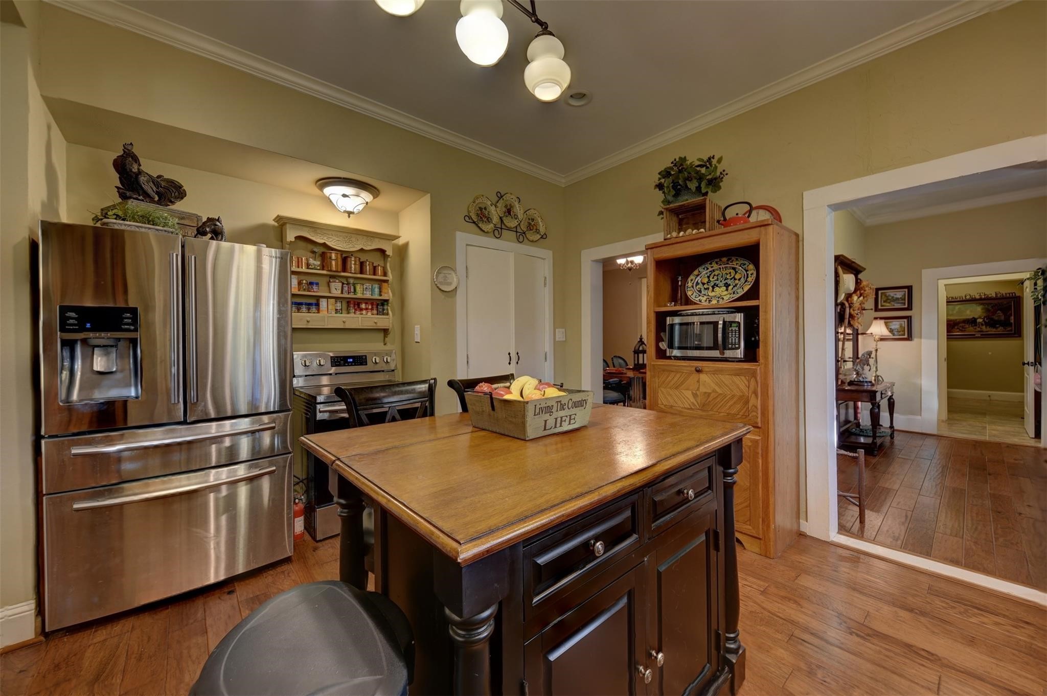 8456 Schuster Road Ledbetter, TX 78946 - Photo 13 of 49 a kitchen with a refrigerator a stove and a dining table with wooden floor