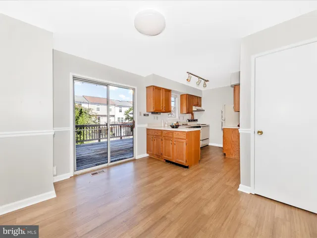 a view of kitchen with stainless steel appliances kitchen island wooden floors and refrigerator