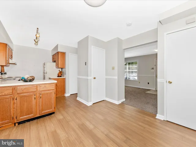 a large white kitchen with wooden floor