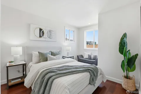a bedroom with a bed and a potted plant