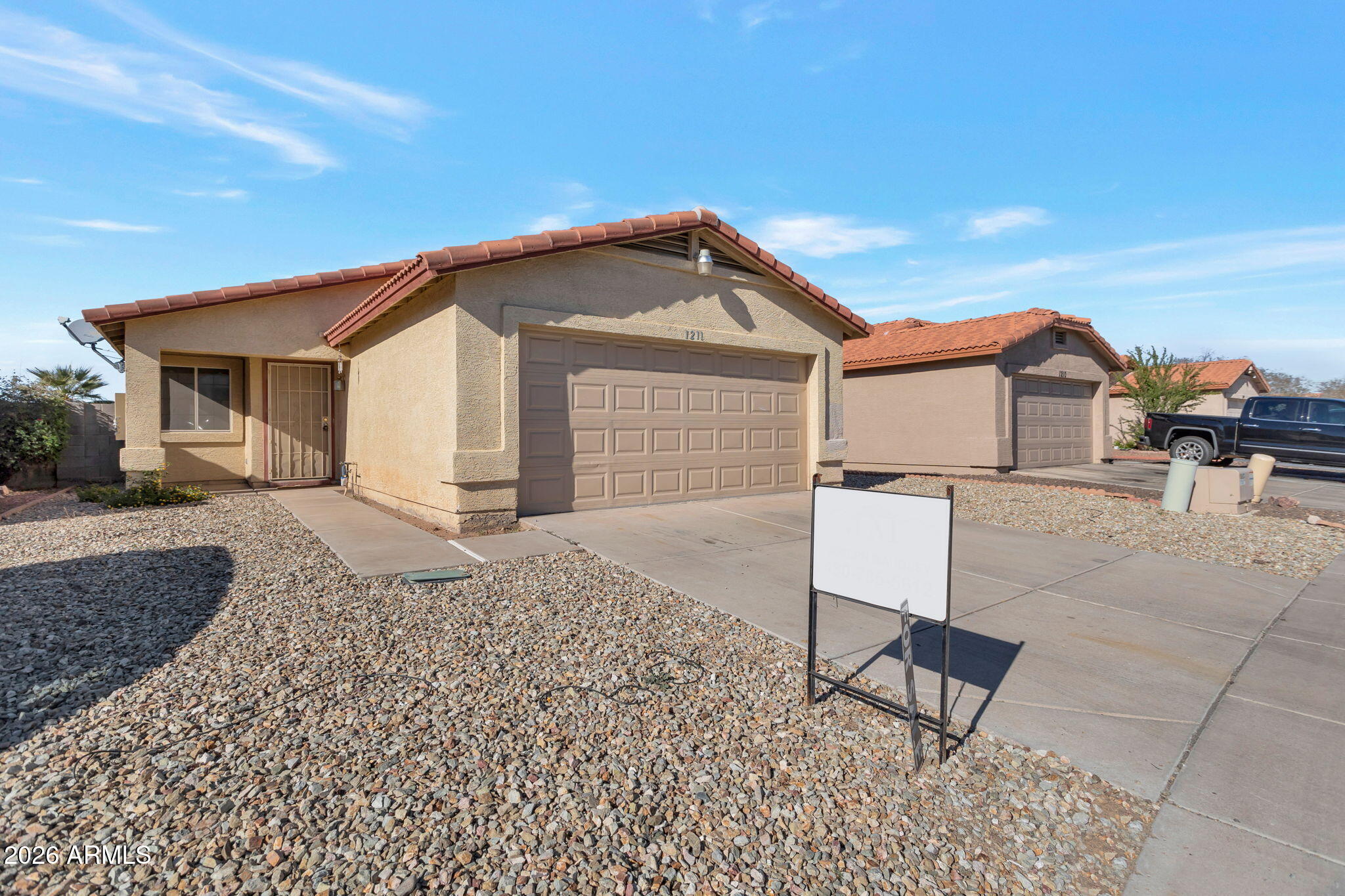 4545 North 67th Avenue, Unit 1211 Phoenix, AZ 85033 - Photo 2 of 16 a front view of a house with a yard and garage