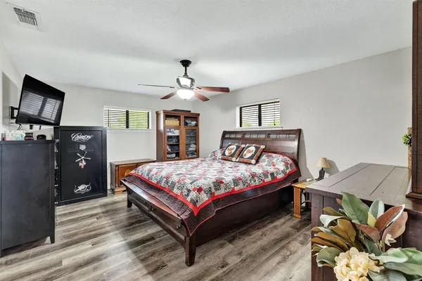 a bedroom with a bed and wooden floor