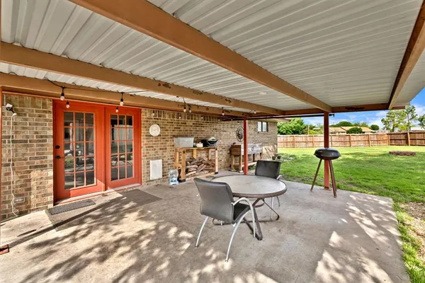 a view of a patio with a table chairs and backyard