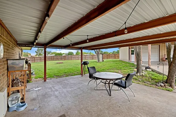 a view of a table and chairs in back yard of a house