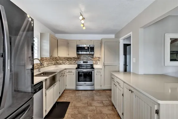 a kitchen with stainless steel appliances granite countertop a stove a sink and a refrigerator