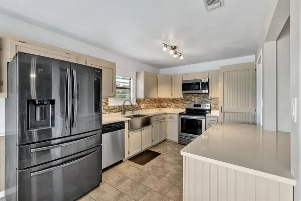 a kitchen with granite countertop stainless steel appliances and white cabinets