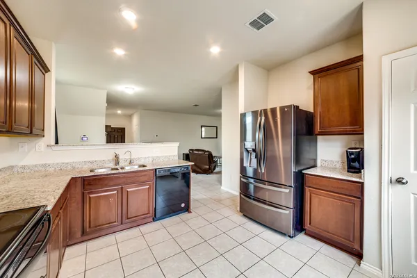 a kitchen with stainless steel appliances granite countertop a refrigerator sink and stove