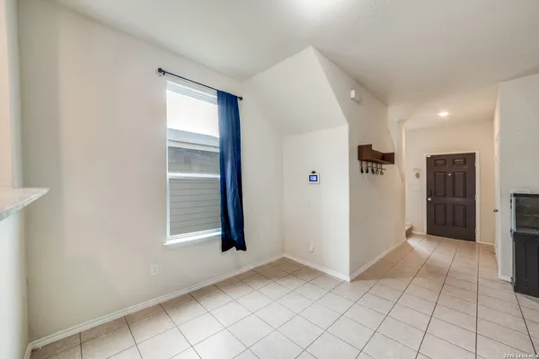 a view of an empty room with window and cabinet