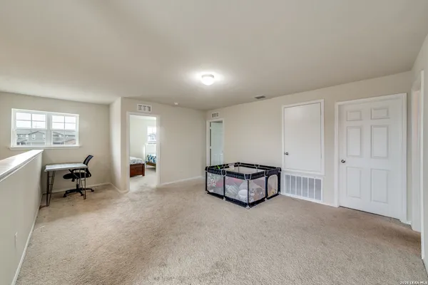 a spacious bedroom with a bed window and table chair