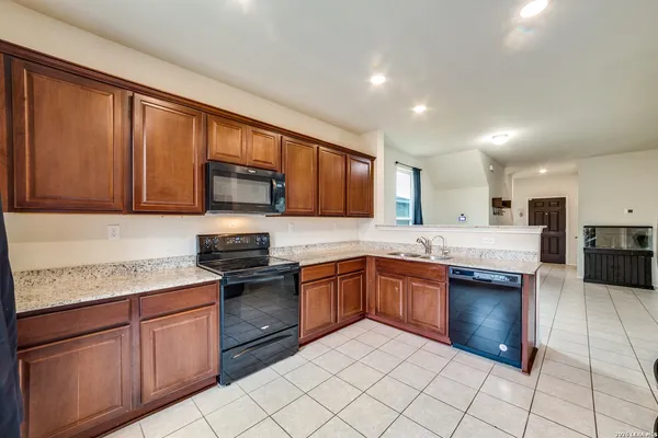 a kitchen with stainless steel appliances granite countertop a stove sink microwave and cabinets