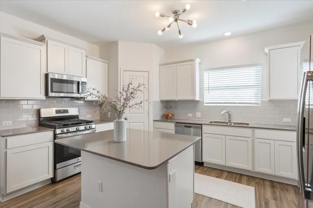 a kitchen with stainless steel appliances a sink stove and microwave