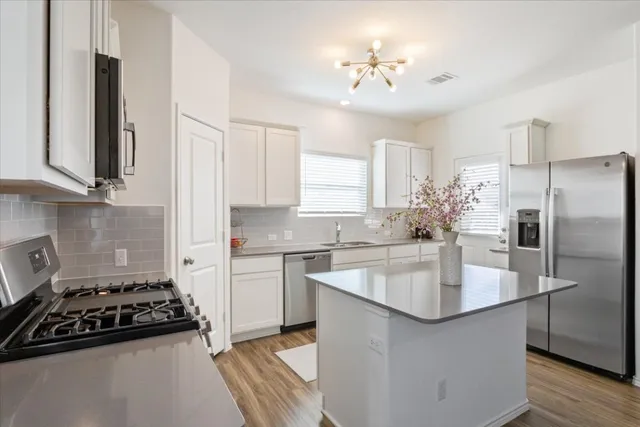 a kitchen with stainless steel appliances a sink stove and refrigerator