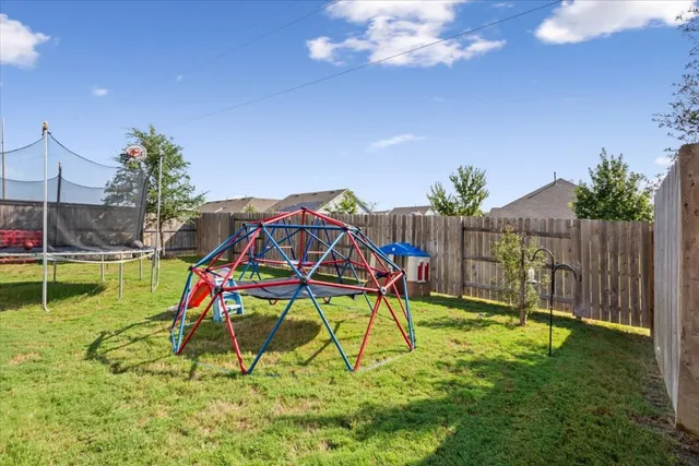a view of swimming pool with a backyard and a slide