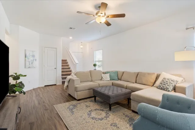 a living room with furniture and wooden floor