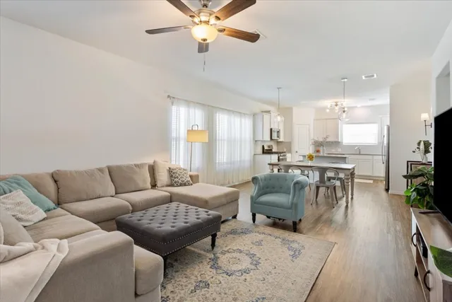 a living room with furniture and a view of kitchen
