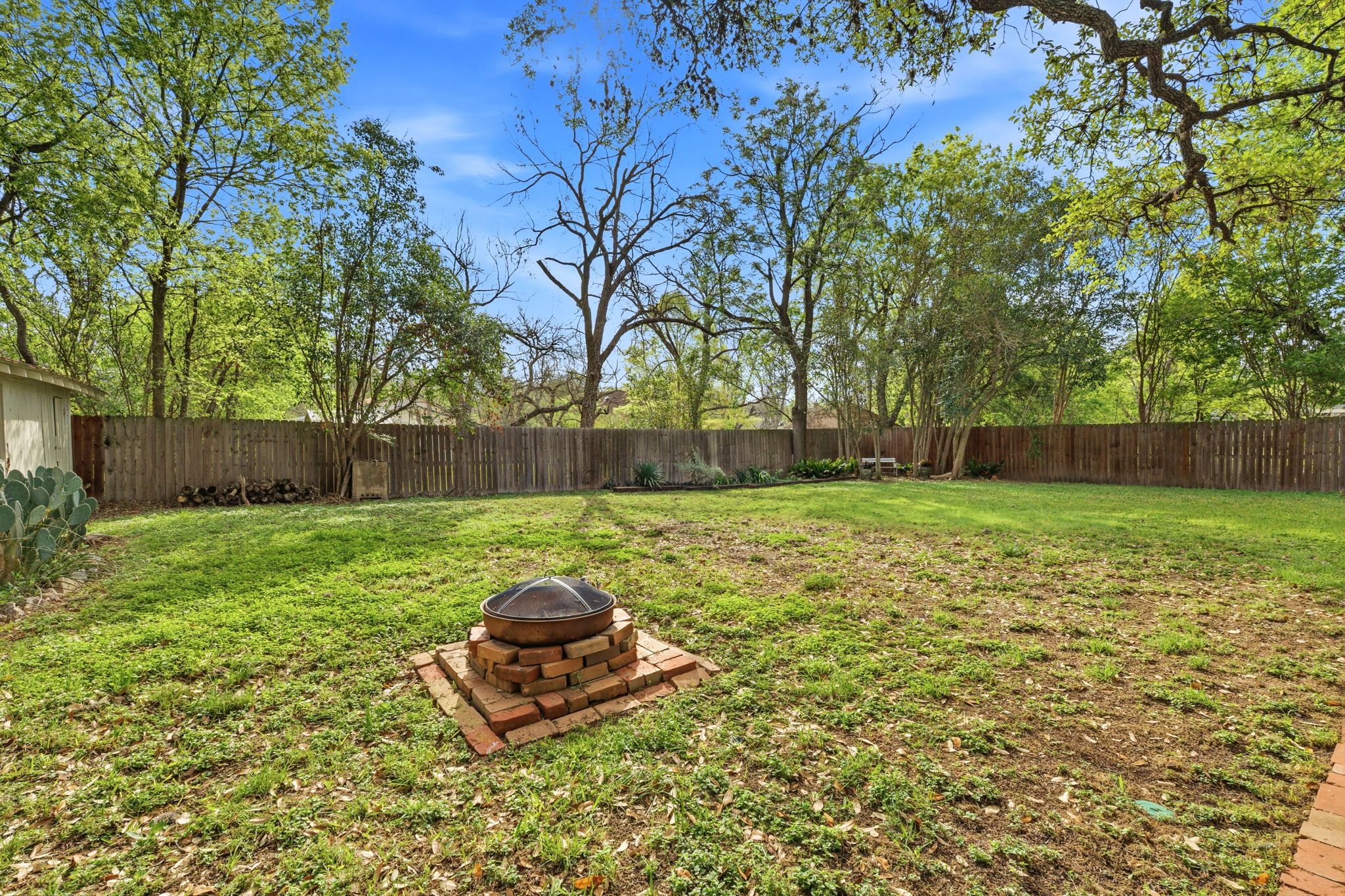 410 Cibilo Street Lockhart, TX 78644 - Photo 23 of 36 a view of a backyard with table and chairs and wooden fence