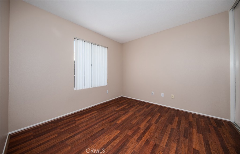 31255 Slate Street Mentone, CA 92359 - Photo 15 of 28 a view of an empty room with wooden floor and a window