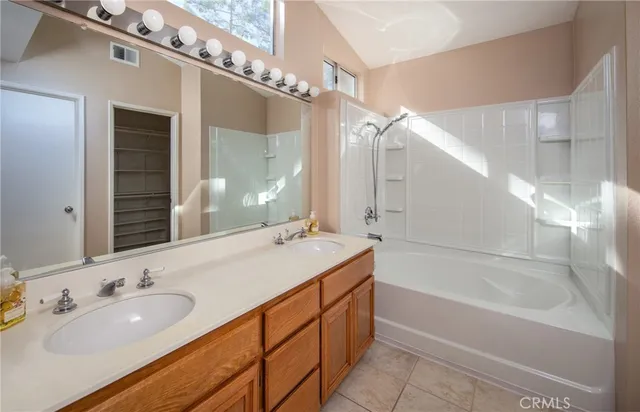 a bathroom with a tub double sink and mirror