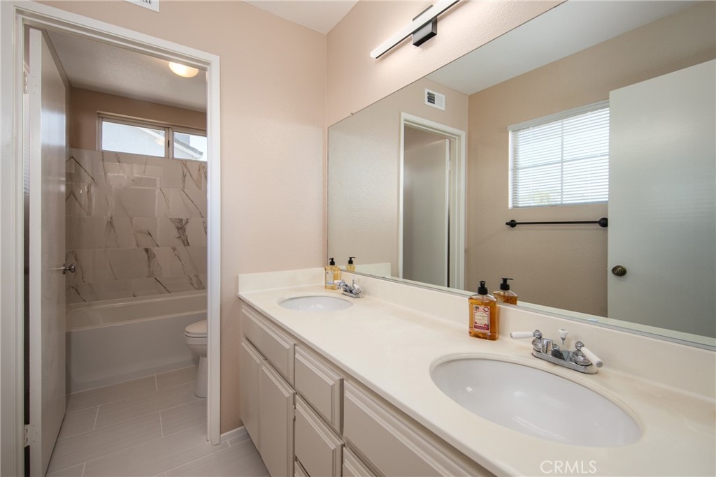 31255 Slate Street Mentone, CA 92359 - Photo 20 of 28 a bathroom with a bathtub a sink a vanity and a shower