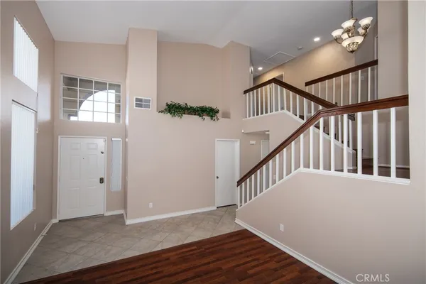 a view of an entryway wooden floor and chandelier