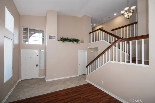 a view of an entryway wooden floor and chandelier