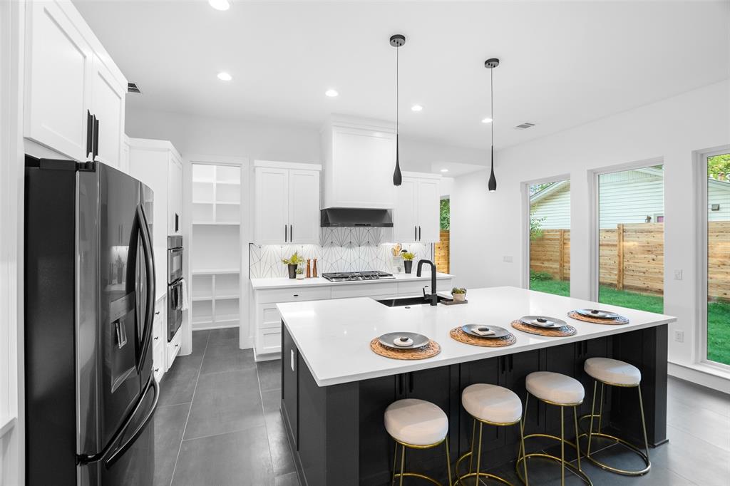 6304 Middleham Place Austin, TX 78745 - Photo 14 of 28 a kitchen with a dining table chairs sink stove and microwave