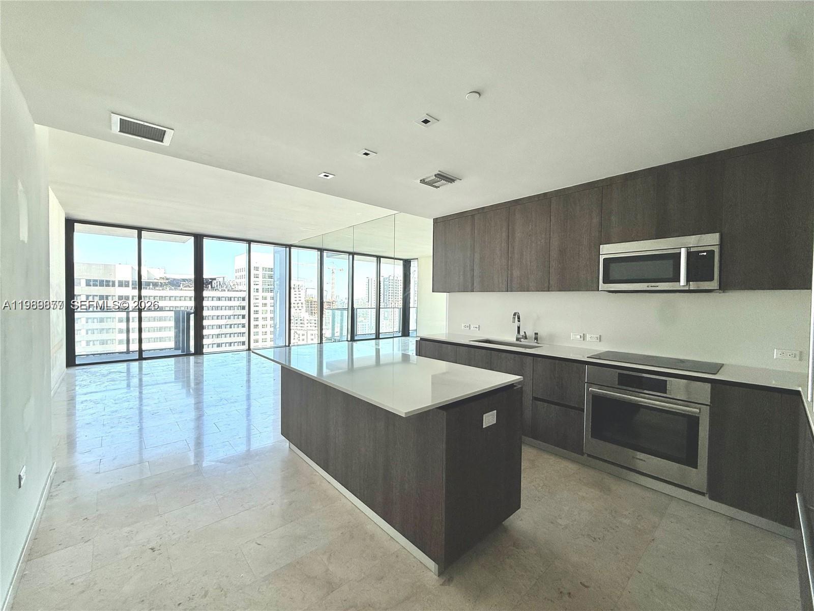 a large kitchen with kitchen island a sink stainless steel appliances and cabinets