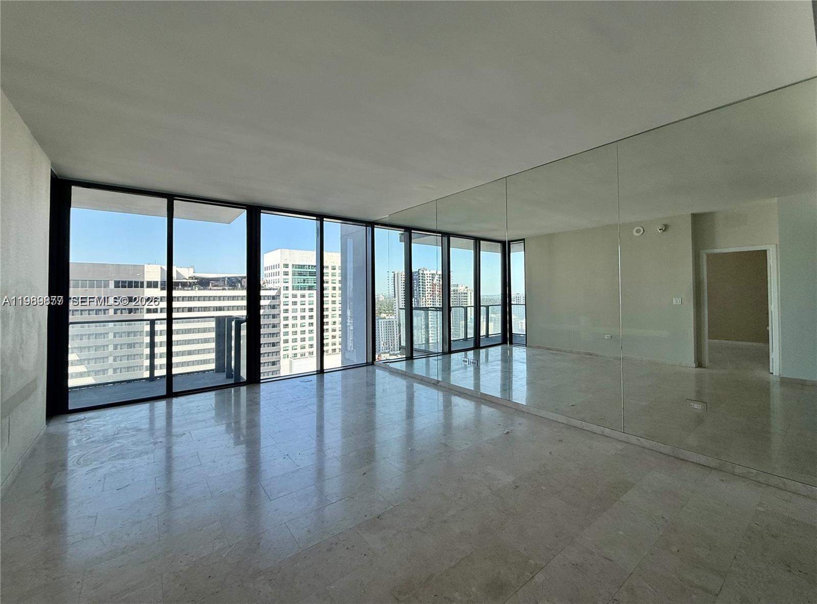 88 Southwest 7th Street, Unit 1808 Miami, FL 33130 - Photo 3 of 9 wooden floor in an empty room with a window