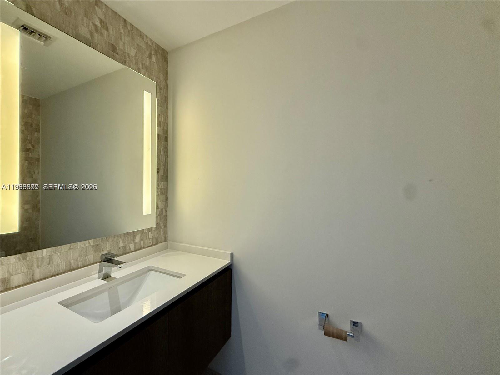 88 Southwest 7th Street, Unit 1808 Miami, FL 33130 - Photo 9 of 9 a bathroom with a sink and a mirror