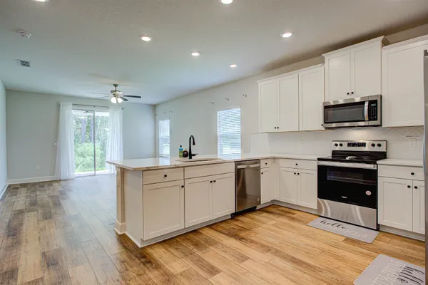 a kitchen with stainless steel appliances kitchen island granite countertop a stove a sink and a microwave