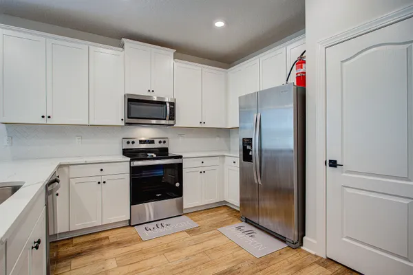 a kitchen with stainless steel appliances granite countertop a refrigerator and a stove top oven