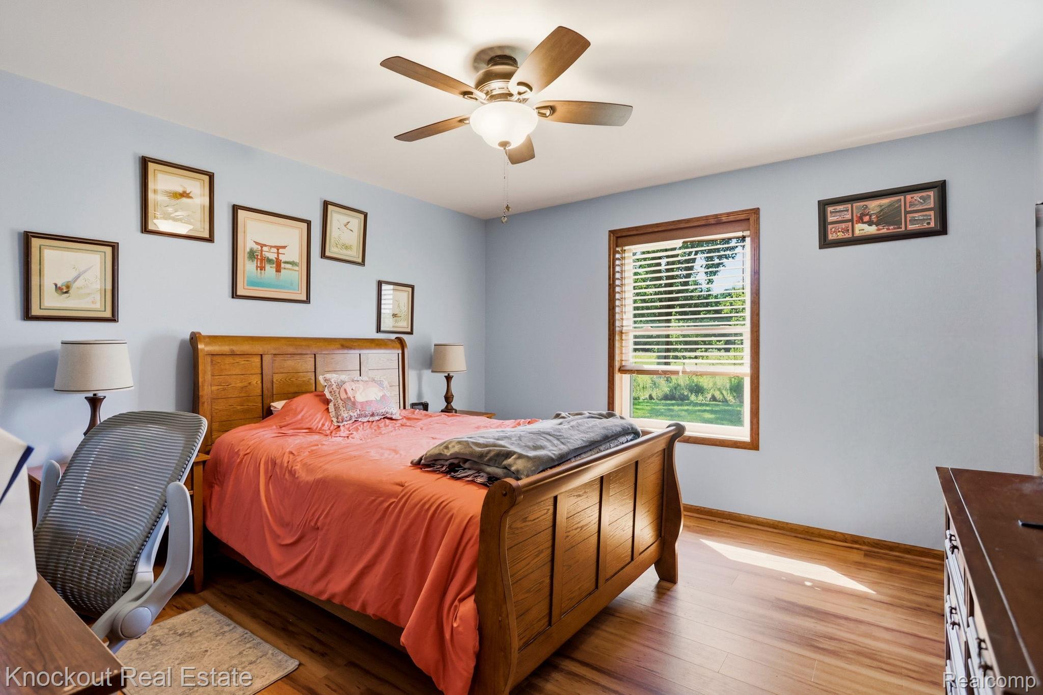5727 Mackinaw Road Saginaw, MI 48604 - Photo 31 of 60 Wood-finish flooring, ceiling fan with integrated lighting, wood-framed window with blinds, and light blue wall finish