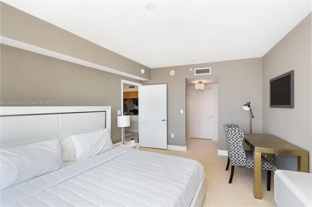 a spacious bedroom with a bed and a chair