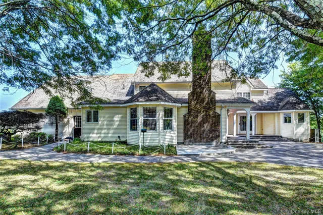 a view of a house with a yard and a forest