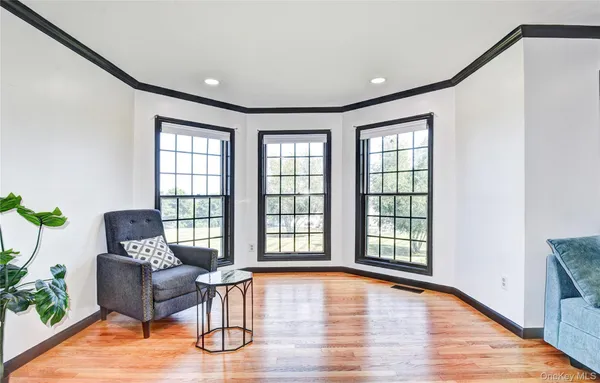 a large kitchen with stainless steel appliances a large counter top a stove a sink a couch and a large window