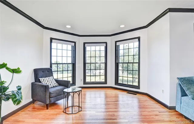 a large kitchen with stainless steel appliances a large counter top a stove a sink a couch and a large window